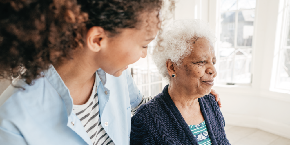 Staff memeber walking with a senior woman down a hallway